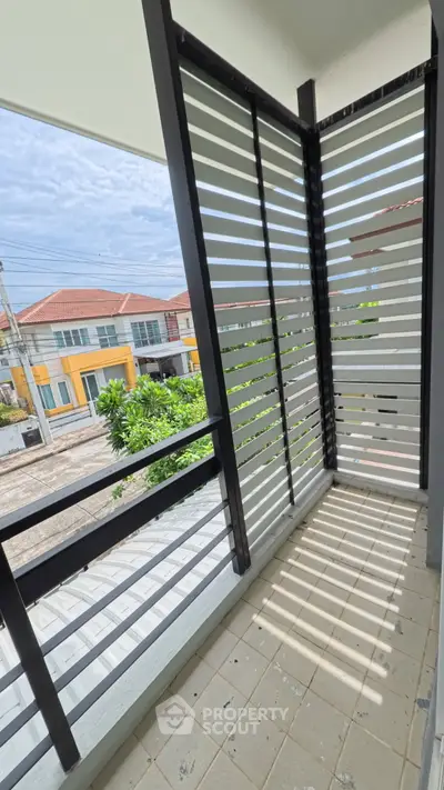 Charming balcony with modern slatted design offering a serene neighborhood view.