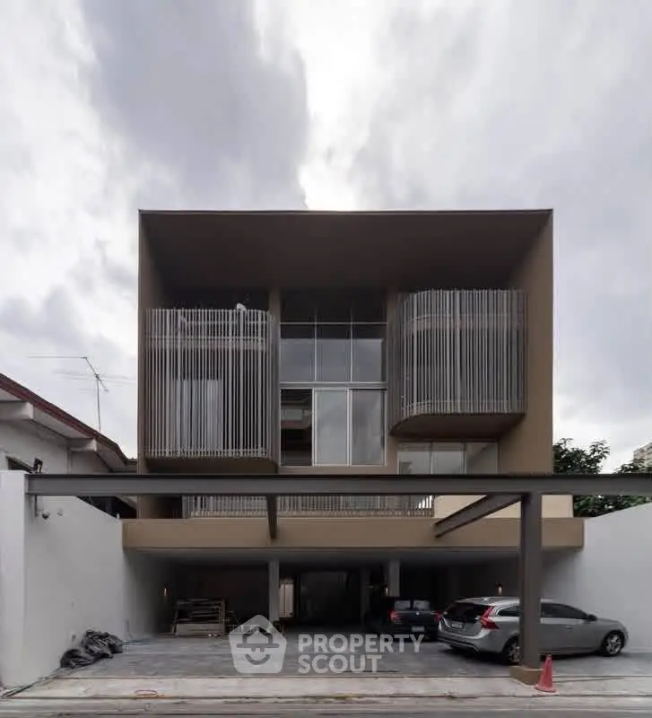 Modern architectural building with unique facade and parking area, showcasing contemporary design and urban living.