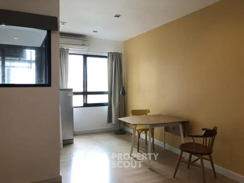 Cozy dining area with natural light and minimalist furniture in modern apartment.