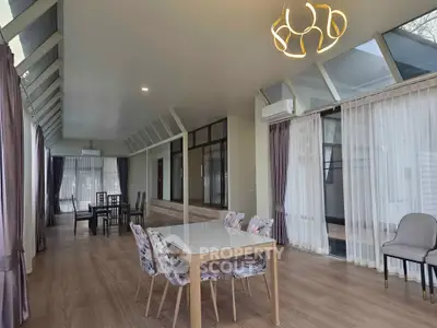 Spacious modern living room with elegant dining area and large windows for natural light.