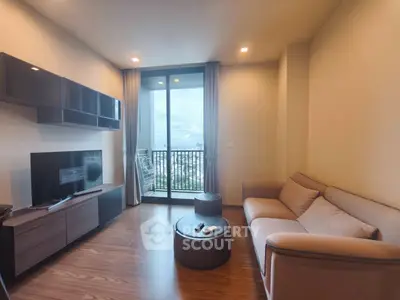 Modern living room with balcony view, featuring sleek furniture and a cozy atmosphere.