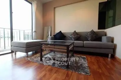 Modern living room with stylish sofa and balcony view, perfect for relaxation and comfort.