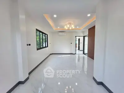 Spacious modern living room with elegant lighting and large windows in a contemporary home.
