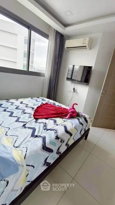 Modern bedroom with stylish decor, featuring a wall-mounted TV and air conditioning, offering comfort and convenience.