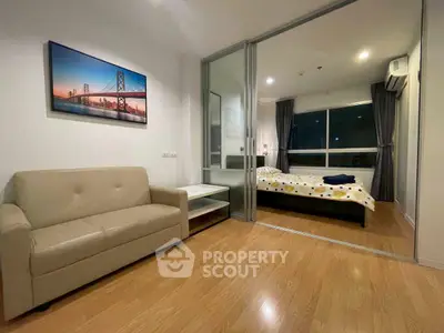 Modern apartment with cozy living room and bedroom separated by glass doors, featuring stylish decor.