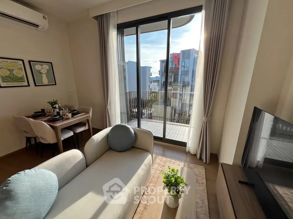 Modern living room with balcony view, stylish decor, and abundant natural light.