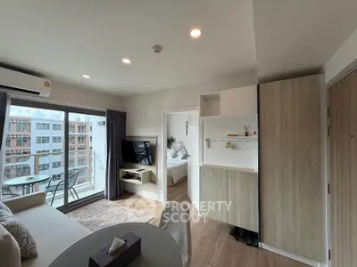 Modern apartment interior with open living room and balcony view, featuring stylish furniture and natural light.