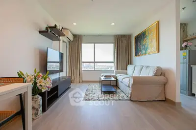Modern living room with large window and stylish decor in a high-rise apartment.