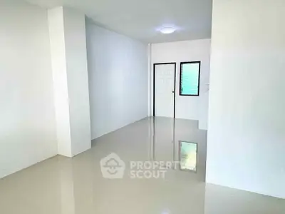 Spacious empty room with glossy tiled floor and white walls, ideal for customization.