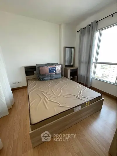 Modern bedroom with large window and stylish furniture in a high-rise apartment.