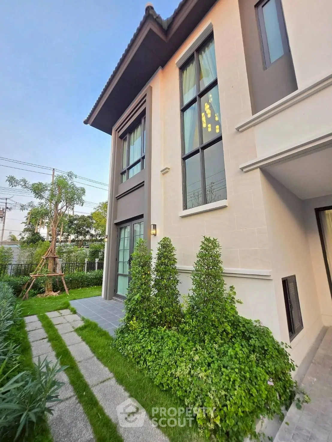 Modern two-story house with lush garden and large windows