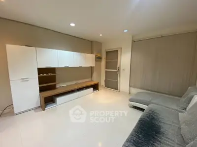 Spacious modern living room with sleek furniture and neutral tones, perfect for relaxation and entertainment.