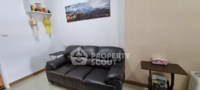 Cozy living room with leather sofa and mountain artwork, perfect for relaxation.