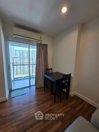 Cozy apartment dining area with balcony view and wooden flooring