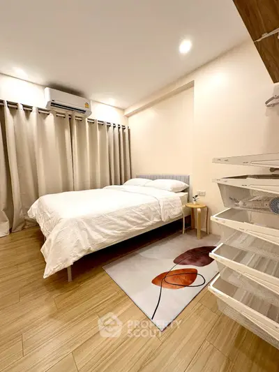 Cozy bedroom with modern decor and ample natural light, featuring a comfortable bed and stylish flooring.
