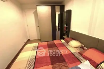 Cozy bedroom with modern wardrobe and stylish bedding in a well-lit apartment.