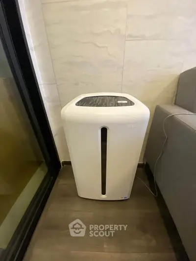 Modern air purifier in stylish living room corner with sleek design and neutral tones.