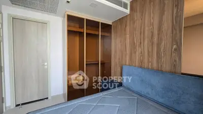 Modern bedroom with built-in wooden wardrobe and stylish blue headboard