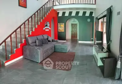 Spacious living room with modern decor and stylish staircase in a contemporary home.