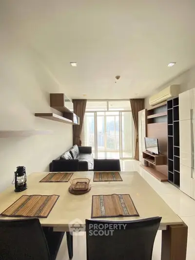 Modern living room with sleek furniture and large windows offering city views