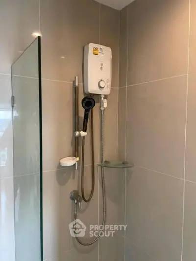 Modern bathroom shower area with sleek design and electric water heater.