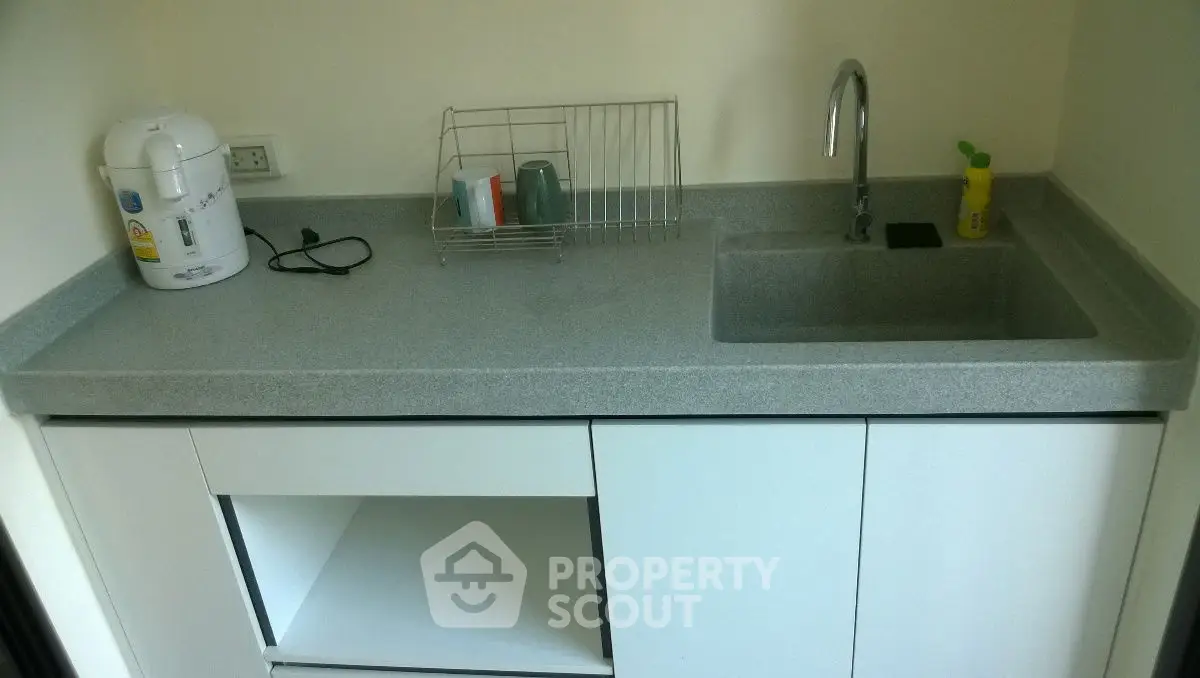 Compact kitchen with sleek countertop and modern sink