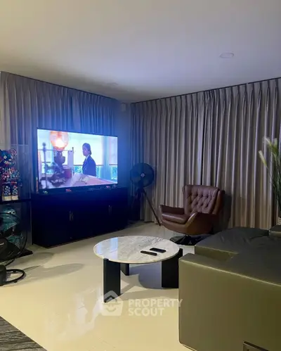 Modern living room with sleek furniture and large TV, perfect for relaxation and entertainment.