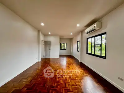 Spacious living room with elegant wooden flooring and large windows for natural light.