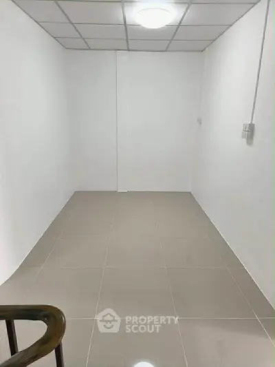 Minimalist small room with tiled floor and white walls, ideal for storage or utility use.