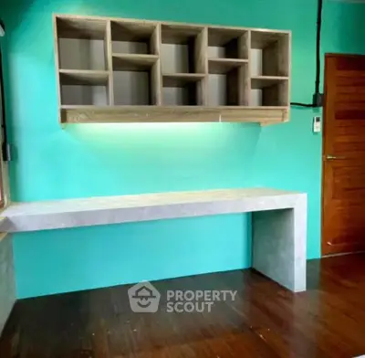 Modern study room with built-in wooden shelves and sleek desk on polished floor.