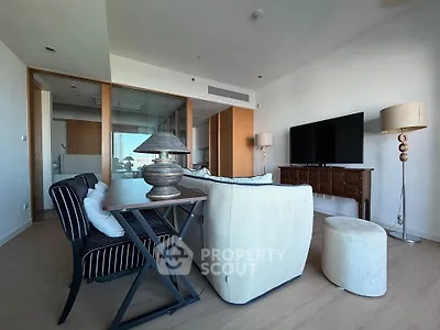Spacious modern living room with stylish furniture and large TV, perfect for relaxation and entertainment.