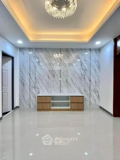 Luxurious modern living room with marble accent wall and elegant chandelier