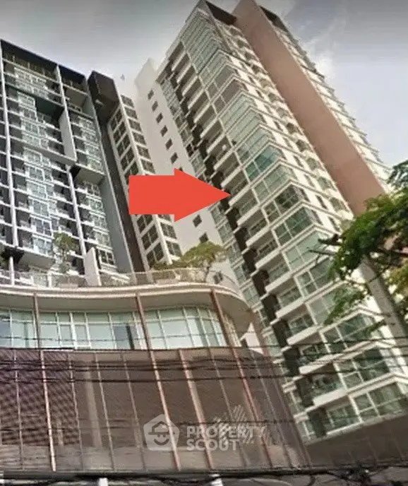 Modern high-rise building exterior with glass facade and urban surroundings.