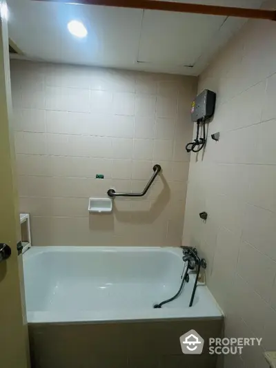 Compact bathroom with bathtub and wall-mounted water heater