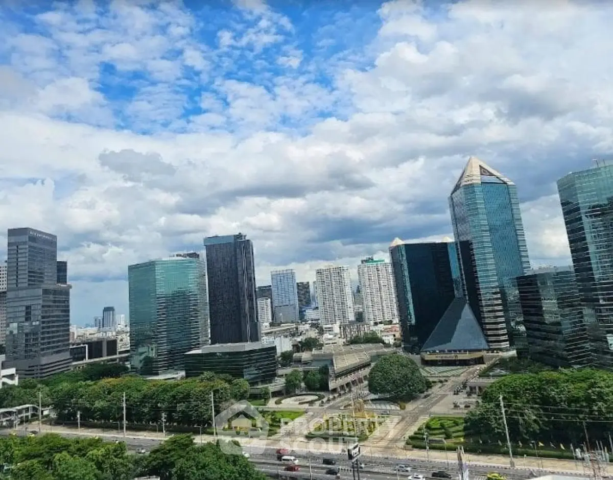 Stunning cityscape view of modern skyscrapers and lush greenery under a vibrant blue sky.