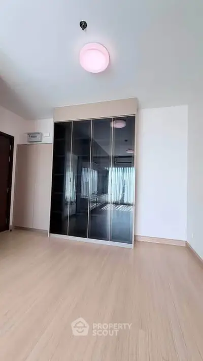 Spacious bedroom with sleek built-in wardrobe and modern lighting
