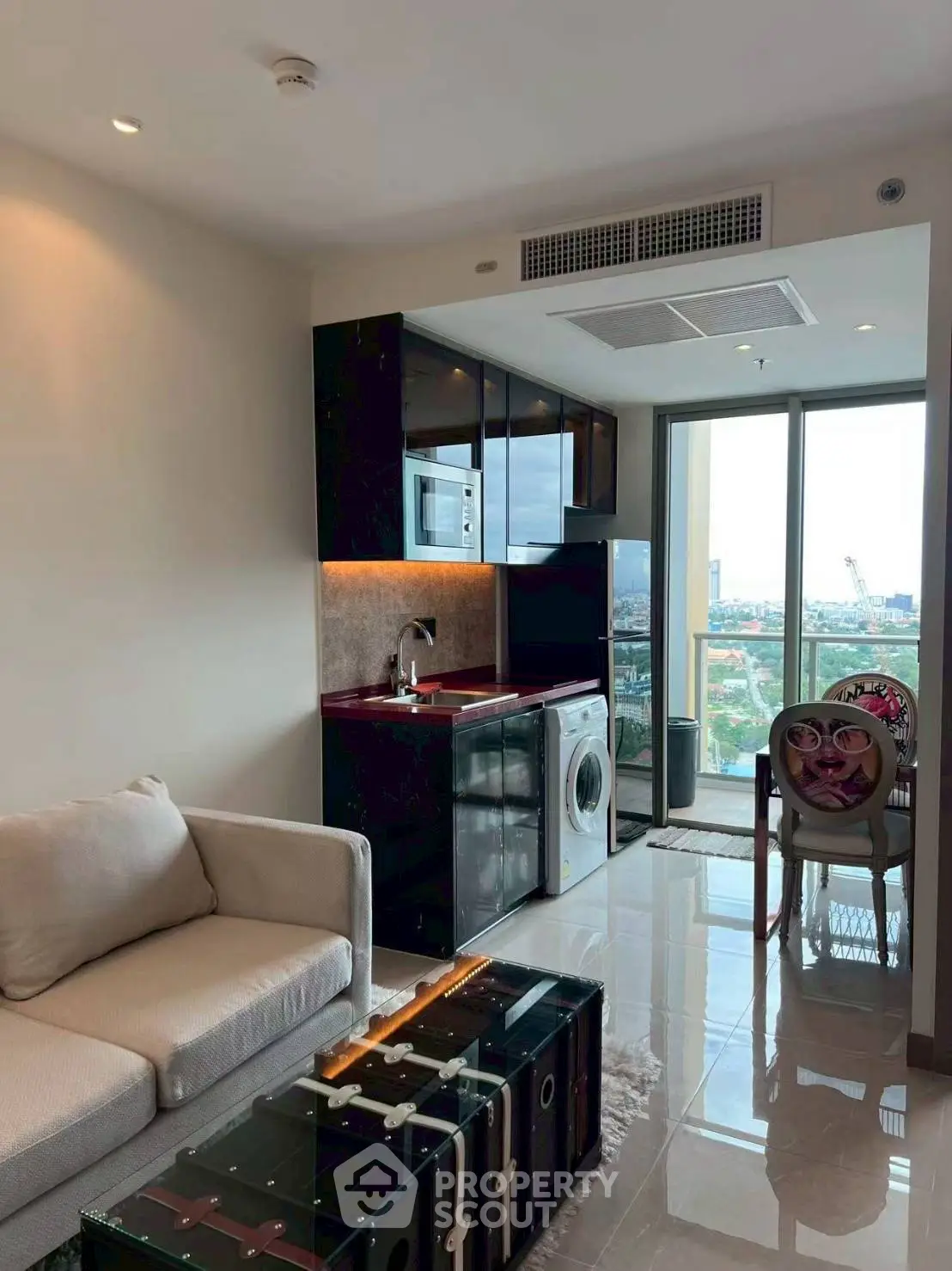 Modern living room with open kitchen and balcony view in high-rise apartment