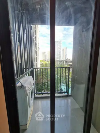 Modern balcony with city view and washing machine, perfect for urban living.