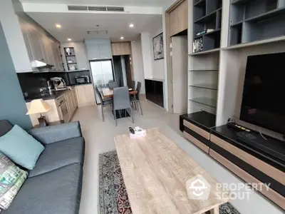 Modern open-layout living room with kitchen, featuring sleek furniture and contemporary design.