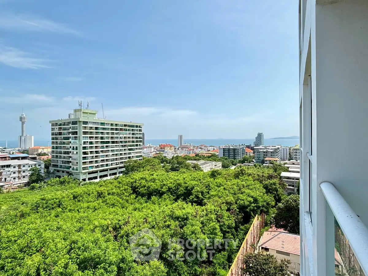 Stunning cityscape view from high-rise balcony overlooking lush greenery and skyline.