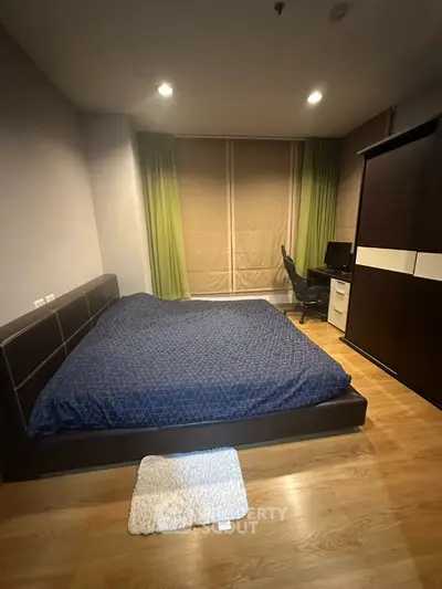 Modern bedroom with wooden flooring and stylish furniture