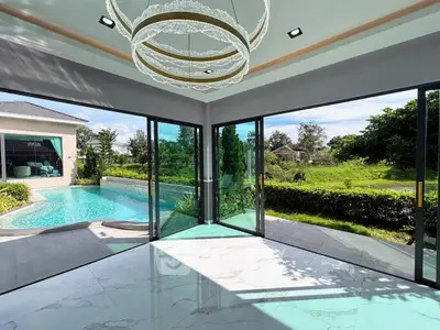 Luxurious living room with pool view and modern chandelier in a corner unit