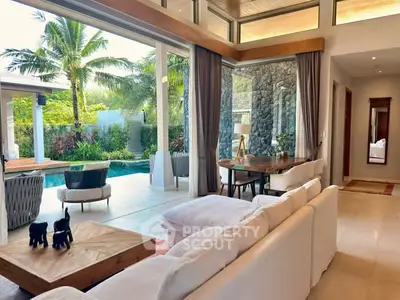 Luxurious open living room with pool view and tropical garden, perfect for relaxation and entertaining.