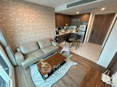 Modern living room with open kitchen, stylish decor, and cozy seating area in a contemporary apartment.
