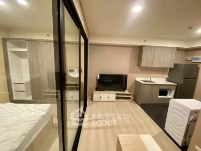 Modern studio apartment with open layout, featuring a compact kitchen and cozy living area.