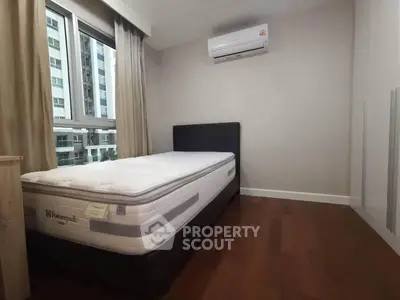 Modern bedroom with large window and air conditioning in urban apartment