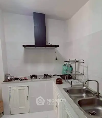 Modern kitchen with sleek gas stove and dual sink in compact layout