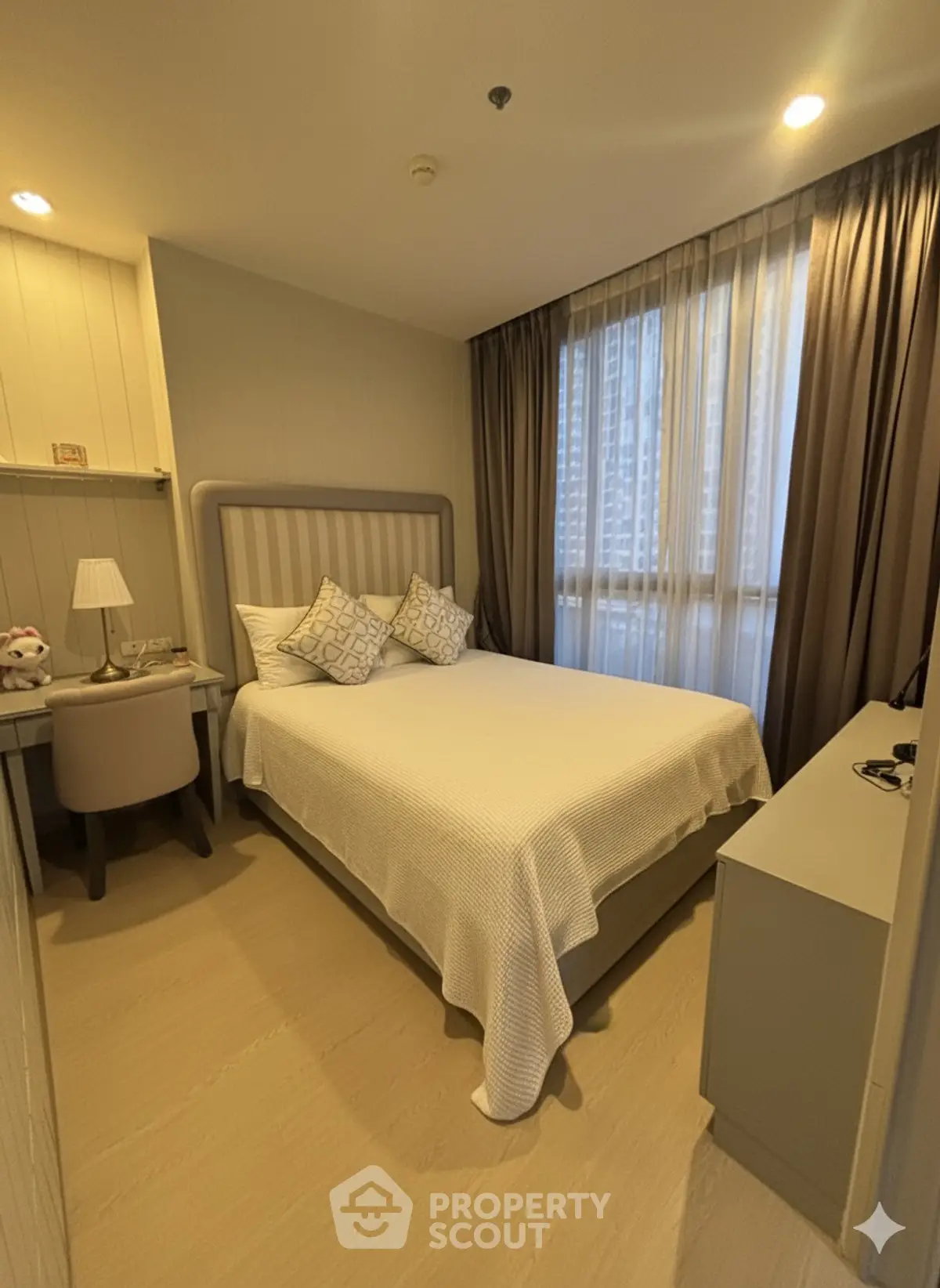 Cozy bedroom with modern decor and ample natural light in a stylish apartment.