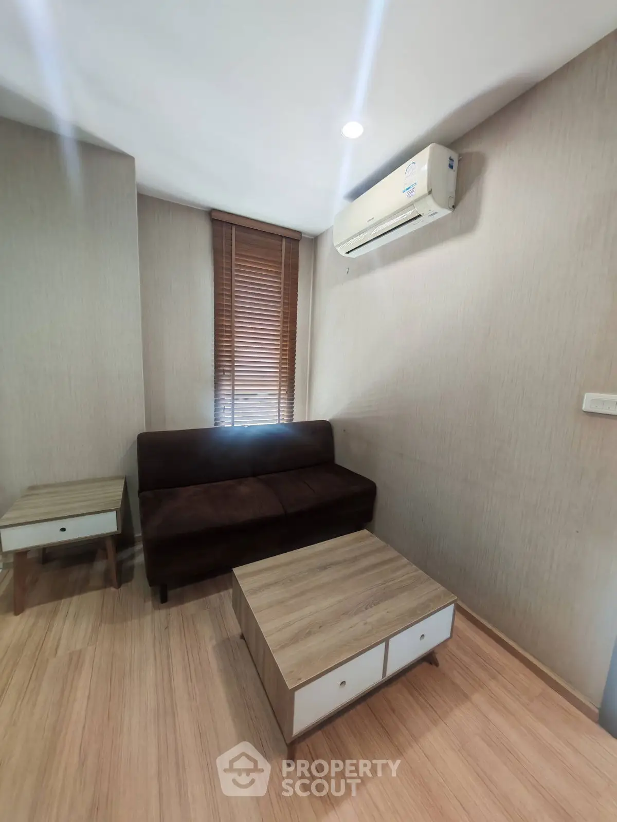 Cozy living room with modern furniture and air conditioning, perfect for relaxation.