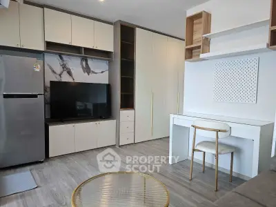 Modern living room with sleek furniture and built-in storage, featuring a TV and stylish decor.